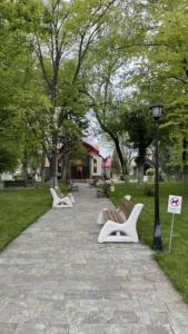 Пейзаж с пейки и дървета в парка на Дома на доброто, водещ към параклиса.