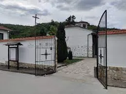 Входната порта на църквата „Св. Георги“ в село Златолист – бели зидове с железни порти, водещи към святото място, разположено сред планинска тишина.
